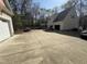 A large backyard featuring a spacious driveway, garage, and wooded area at 63 Tally Ho Dr, Selma, NC 27576