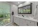 Bathroom with double sinks, white marble countertops, and large window at 63 Tally Ho Dr, Selma, NC 27576