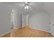 Bright bedroom with hardwood floors, ceiling fan, and doorway to an adjacent room at 63 Tally Ho Dr, Selma, NC 27576