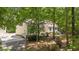 Charming home with mature trees, features a side entry garage and inviting front steps and is surrounded by lush greenery at 63 Tally Ho Dr, Selma, NC 27576