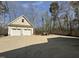 Two-car garage with a large driveway and some woods in the background at 63 Tally Ho Dr, Selma, NC 27576