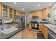 Updated kitchen featuring stainless steel appliances, light wood cabinets, black countertops, and tile flooring at 63 Tally Ho Dr, Selma, NC 27576
