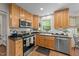 Kitchen with stainless appliances, light wood cabinets, black counter tops, and a window view at 63 Tally Ho Dr, Selma, NC 27576
