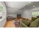 Cozy living room featuring hardwood floors, a comfortable sofa, and a large window at 63 Tally Ho Dr, Selma, NC 27576