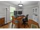 Bright home office featuring hardwood floors, a large window, and a built-in display cabinet at 63 Tally Ho Dr, Selma, NC 27576