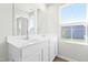 Bright bathroom featuring double sinks, a mirror, and natural light from the window at 653 Corvair Ln, Wendell, NC 27591