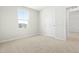 Neutrally decorated bedroom with plush carpeting, a window, and an adjoining room at 653 Corvair Ln, Wendell, NC 27591
