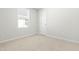 Bright bedroom features neutral carpet, a window, and a door at 653 Corvair Ln, Wendell, NC 27591