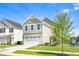 View of the two-story home with a two-car garage, set on a green lawn with blue sky at 653 Corvair Ln, Wendell, NC 27591
