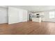 Open-concept living area with wood floors, leading to a modern kitchen with white cabinets at 653 Corvair Ln, Wendell, NC 27591