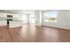 Spacious living area with wood floors, ample natural light, and kitchen with white cabinets at 653 Corvair Ln, Wendell, NC 27591