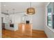 Spacious dining area flows into the living room and kitchen area, wood floors, modern light fixture at 7950 Country Knoll Rd, Bahama, NC 27503