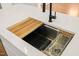 Modern kitchen sink with a cutting board and a drying rack at 7950 Country Knoll Rd, Bahama, NC 27503