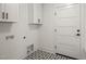 Well-lit laundry room with modern cabinets, patterned tile flooring and washer dryer hookups at 7950 Country Knoll Rd, Bahama, NC 27503