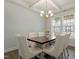 Bright dining area featuring a modern chandelier, large windows, and a stylish table set for a meal at 813 James J Freeland Dr, Hillsborough, NC 27278