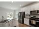 Well-lit kitchen featuring stainless steel appliances, white cabinets, and a functional island, perfect for Gathering gatherings at 813 James J Freeland Dr, Hillsborough, NC 27278