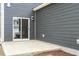 Back patio with sliding glass door and exterior light fixture in a modern gray home at 813 James J Freeland Dr, Hillsborough, NC 27278