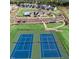 Aerial view of well-maintained community tennis courts near homes and a clubhouse at 813 James J Freeland Dr, Hillsborough, NC 27278