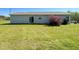Backyard view reveals home with large lawn, shrubbery, and sliding glass doors at 10 Golden Poppy Ln, Youngsville, NC 27596