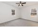 Light-filled bedroom with neutral carpet, ceiling fan, and two bright windows at 100 Gates St, Roxboro, NC 27573