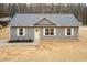 Charming single-story home with gray siding, white trim, and a bright yellow front door at 100 Gates St, Roxboro, NC 27573