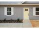Close up of a house with a bright yellow door and gray siding at 100 Gates St, Roxboro, NC 27573