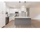 Bright kitchen featuring stainless steel appliances, white cabinets, and a gray island with granite countertops at 100 Gates St, Roxboro, NC 27573