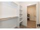 Walk-in closet with built-in shelving and rod, leading to utility room at 100 Gates St, Roxboro, NC 27573
