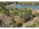 Scenic aerial view of home nestled among trees near a tranquil lake at 100 Lochberry Ln, Cary, NC 27518