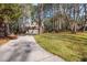 View of the back of the home showing a long driveway, and a wooded lot providing a secluded feel at 100 Lochberry Ln, Cary, NC 27518