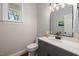 Classic half-bath with a dark vanity, white sink, and a window at 100 Lochberry Ln, Cary, NC 27518