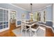 Elegant dining room with large windows, modern lighting, and a stylish table and bench set at 100 Lochberry Ln, Cary, NC 27518