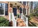 Inviting front porch features brick steps with white railings and a classic black door with decorative accents at 100 Lochberry Ln, Cary, NC 27518