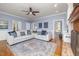 Cozy living room featuring a ceiling fan, fireplace, and blue area rug at 100 Lochberry Ln, Cary, NC 27518