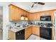 Functional kitchen featuring wooden cabinets, black appliances, and tiled flooring at 105 Elizabeth St, Chapel Hill, NC 27514