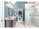 Bathroom with granite countertop vanity, glass shower door, and view into the bedroom at 109 S Fern Abbey Ln, Cary, NC 27518