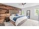 Bedroom featuring a wood accent wall, tufted headboard, neutral carpet, and a ceiling fan at 109 S Fern Abbey Ln, Cary, NC 27518