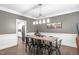 Dining room with a rustic wood table, metal chairs, modern light fixture, and white wainscoting at 109 S Fern Abbey Ln, Cary, NC 27518