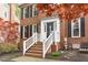 Charming brick home featuring a classic entryway with white railing and black front door at 109 S Fern Abbey Ln, Cary, NC 27518