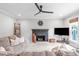 Cozy living room featuring a stone fireplace, ceiling fan, and neutral decor at 109 S Fern Abbey Ln, Cary, NC 27518