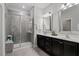 Modern bathroom with double sinks, dark cabinetry, and a glass-enclosed tiled shower at 109 Shale Creek Dr, Durham, NC 27703