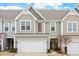 Charming townhome featuring a well-maintained front yard, attached garage, and inviting facade with interesting architectural details at 109 Shale Creek Dr, Durham, NC 27703