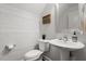 Stylish powder room with wood paneled walls, a sleek pedestal sink, and modern fixtures offering simple elegance at 109 Shale Creek Dr, Durham, NC 27703