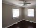 Neutral bedroom featuring hardwood floors, ceiling fan, and windows with blinds at 1220 Garner Rd, Raleigh, NC 27610