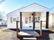 Inviting single-story home with a cozy, covered porch featuring appealing dark wooden pillars and well-kept front yard at 1220 Garner Rd, Raleigh, NC 27610