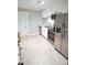 Well-lit kitchen featuring modern stainless steel appliances, sleek white cabinets, and bright countertops at 1220 Garner Rd, Raleigh, NC 27610