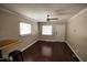 Bright living room with a ceiling fan, hardwood floors, and two windows letting in natural light at 1220 Garner Rd, Raleigh, NC 27610