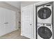 Hallway featuring a laundry closet with stacked washer and dryer at 1234 Coach Station Alley # 101, Raleigh, NC 27601