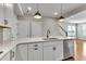 Kitchen island with white countertops and stainless steel dishwasher overlooking the living area at 1234 Coach Station Alley # 101, Raleigh, NC 27601