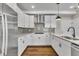 A beautifully designed kitchen features white cabinetry, stainless steel appliances, and hardwood floors at 1234 Coach Station Alley # 101, Raleigh, NC 27601